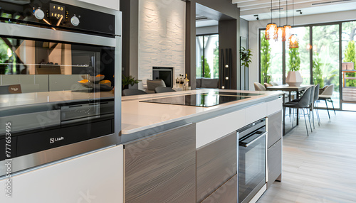 Interior of modern kitchen with island, built-in oven and white counters