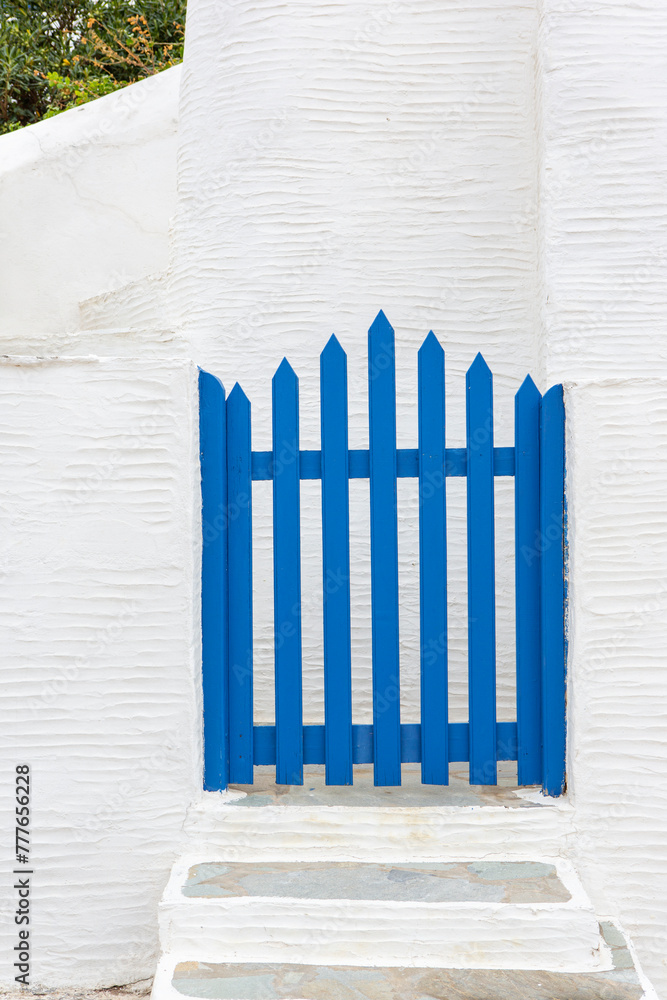 Facade of brick fence or small white wall with a blue gate to enter Facade of brick fence or small white wall with a blue gate to enter