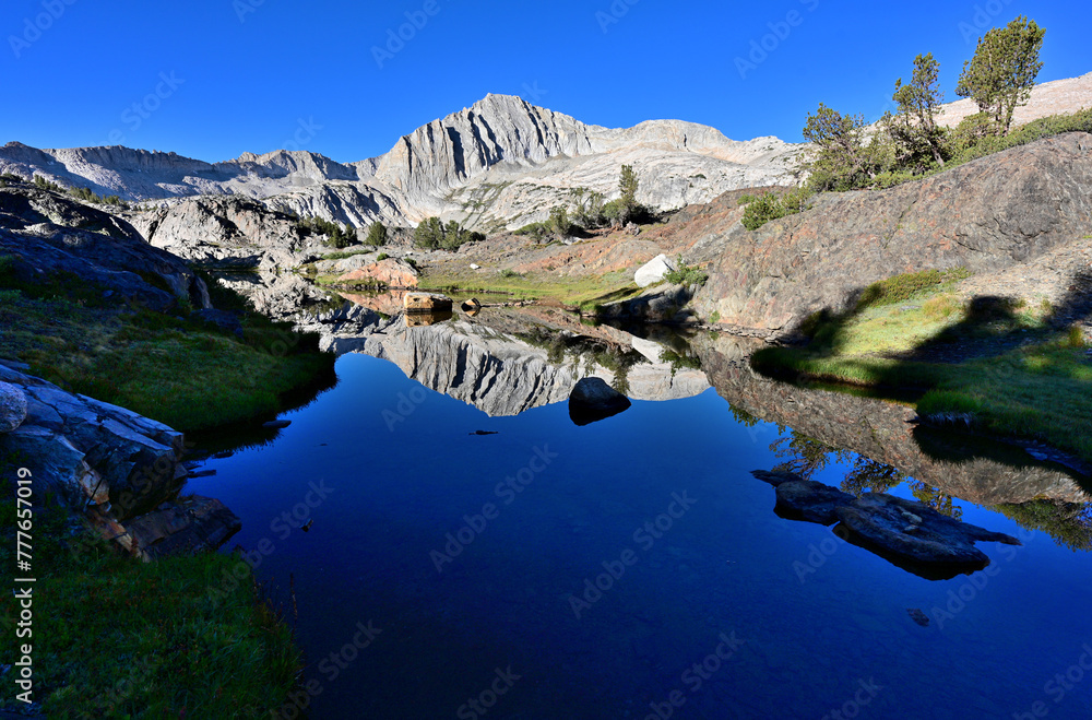 An unnamed pond in the Twenty Lakes Basin of the Sierra Nevada Mountains in California reflects a sunlite North Peak.


