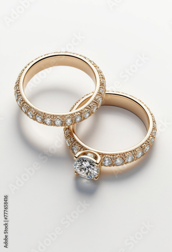 two delicate gold wedding rings with stones with a white background