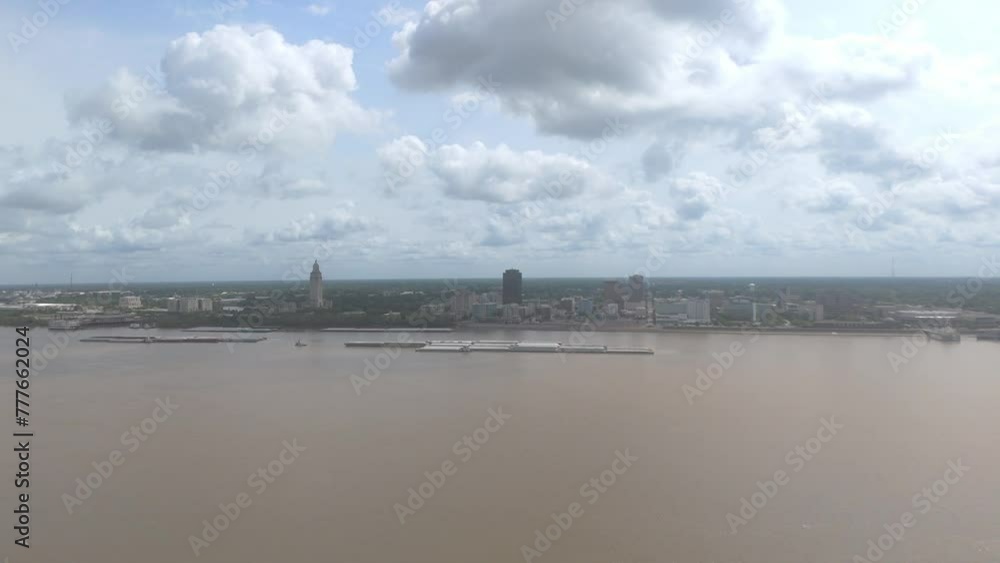 Aerial of barges on the Mississippi River and the skyline of Baton Rouge City in the background Aerial of barges on the Mississippi River and the skyline of Baton Rouge City in the background