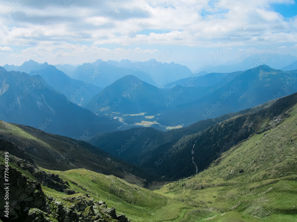 Obraz premium Panoramic view of alpine terrain surrounded by majestic Carnic Alps, Carinthia, border Italy Austria. Scenic hiking trail in wilderness of Austrian Alps. Peace of mind, calmness. Wanderlust in nature