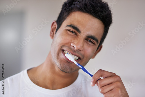 Happy, portrait and man with toothbrush in bathroom for dental hygiene, gum disease and oral care. Health, mouth and face of person brushing teeth for wellness, cleaning and fresh breath in home