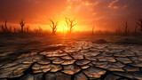 Cracked dry land with dead trees and sky in the background, concept of global warming