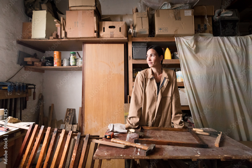 Happy female carpenter at small workshop Happy female carpenter at small workshop