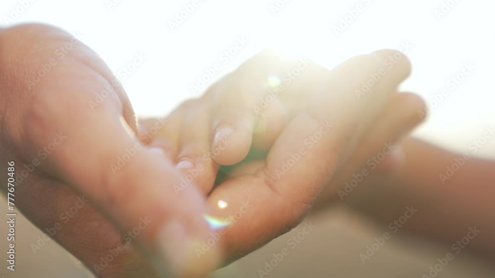 Hand in hand close up.father holds child's hand.baby's dream.hands baby and dad together at sunset outdoors.clasped hands as sign support.helping hand.happy child.family support.happy family concept Hand in hand close up.father holds child's hand.baby's dream.hands baby and dad together at sunset outdoors.clasped hands as sign support.helping hand.happy child.family support.happy family concept