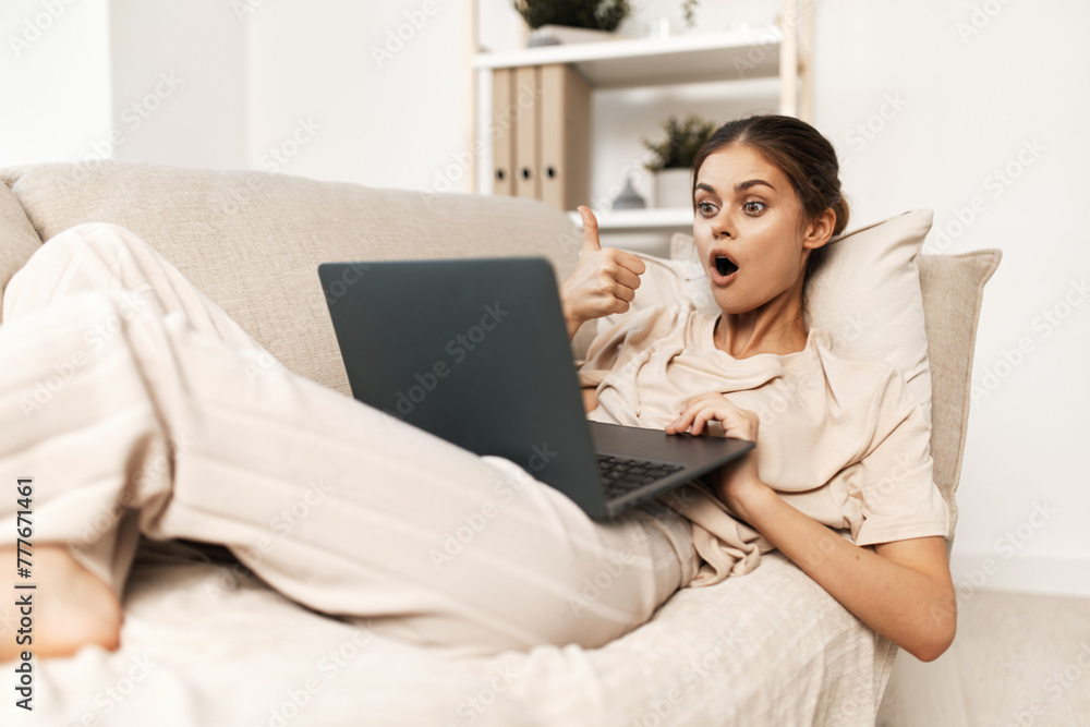 Smiling Woman Working from Home with Laptop in Cozy Living Room Smiling Woman Working from Home with Laptop in Cozy Living Room