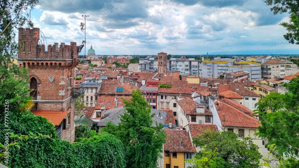 Aerial panoramic view of historic city of Udine, Friuli Venezia Giulia, Italy, Europe. Viewing platform form castle of Udine. Dark clouds on overcast day. Classical Italian architecture red roofs