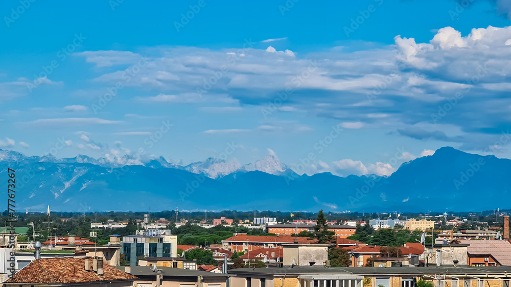 Aerial panoramic view of historic city of Udine, Friuli Venezia Giulia, Italy, Europe. Viewing platform form castle of Udine. Cloudy overcast day. Distant view of mountains of Alps, border to Austria