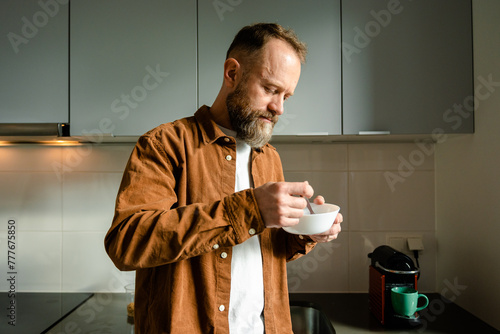 A man eats in the kitchen photo