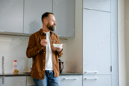 A man eats in the kitchen photo