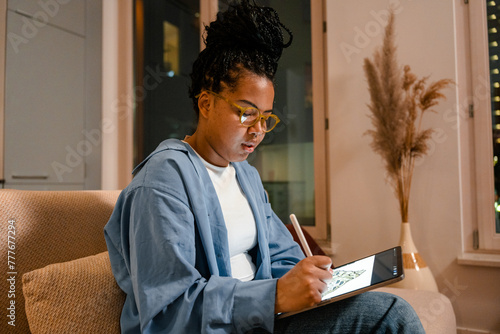 A woman draws on a tablet at home photo