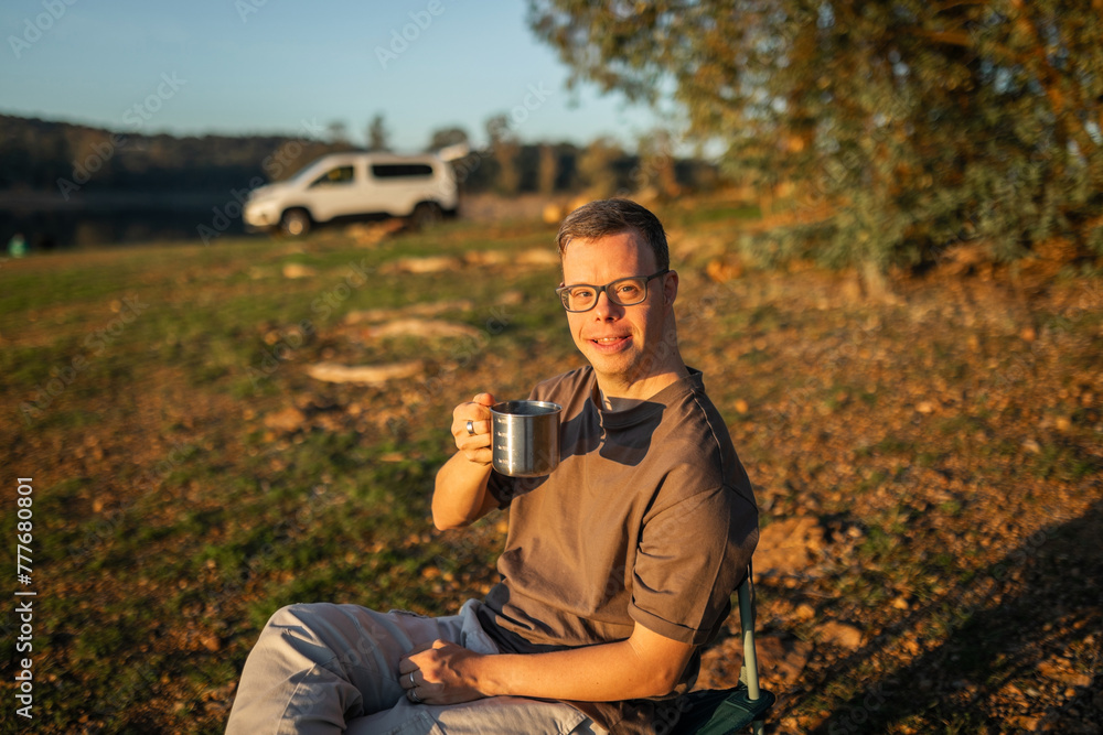 man with down syndrome drinking coffee in nature man with down syndrome drinking coffee in nature