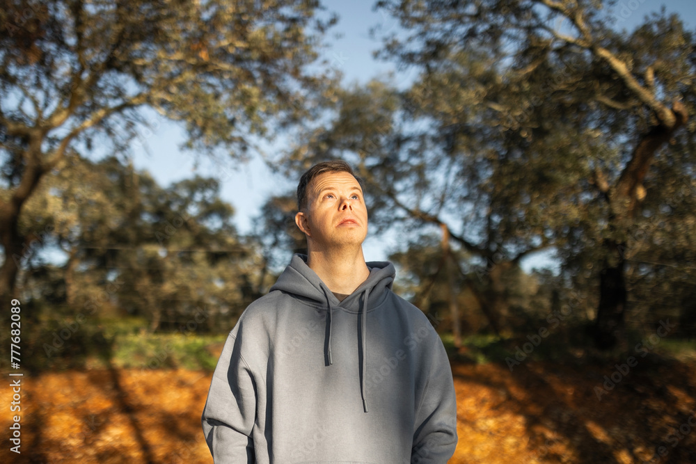 portrait of young man with down syndrome in nature portrait of young man with down syndrome in nature
