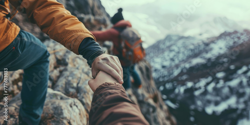 A group of rock climbers climb a mountain, helping each other.