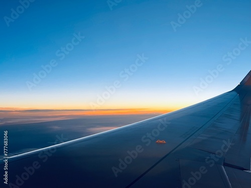 view from the airplane window, sunrise time, tender colors of the sky  © Oksana