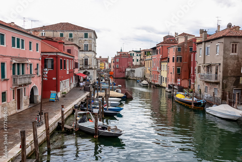 Scenic view of peaceful canal Vena nestled in charming town of Chioggia, Venetian Lagoon, Veneto, Italy. Small boats floating in calm water. Enchanting reflections create atmosphere of tranquility