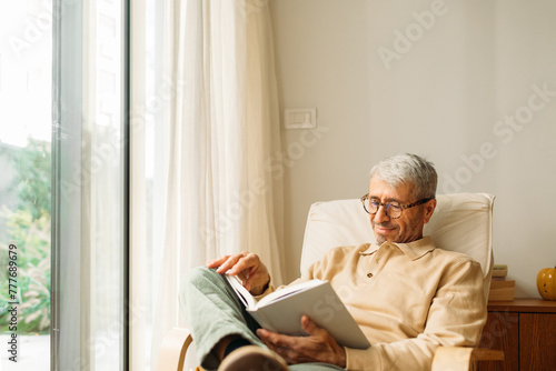 Senior man reading in his home photo