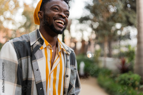 cheerful african american man in checkered shirt smiling at camera photo