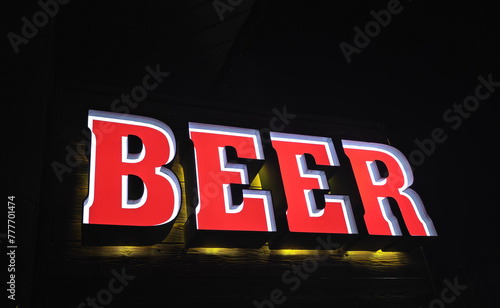 Glowing red Beer sign at entrance to pub at night