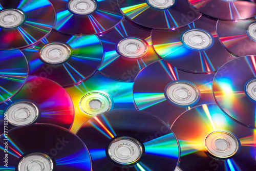 Randomly arranged vintage compact discs with colorful lights photo