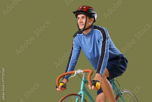 Young man riding bicycle on...