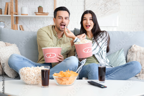 Young couple with popcorn w...