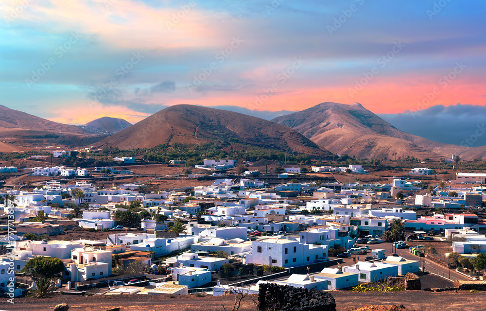 Landscape aerial view of the Municipality of Yaiza village illuminated by the sunset at the foot of the volcanic mountain, in Lanzarote - Canary Islands, Spain