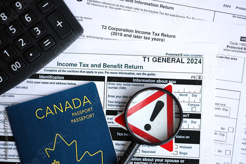 Concept of problems and troubles during tax reporting and taxpaying in Canada. Accountant table with canadian tax forms photo