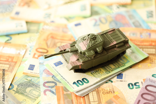 Many euro banknotes and tank. Lot of bills of European union currency and green tank close up © mehaniq41