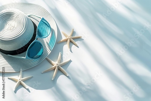 A stylish beach hat and sunglasses casting shadows on a clean surface with starfish Ideal for summer themes