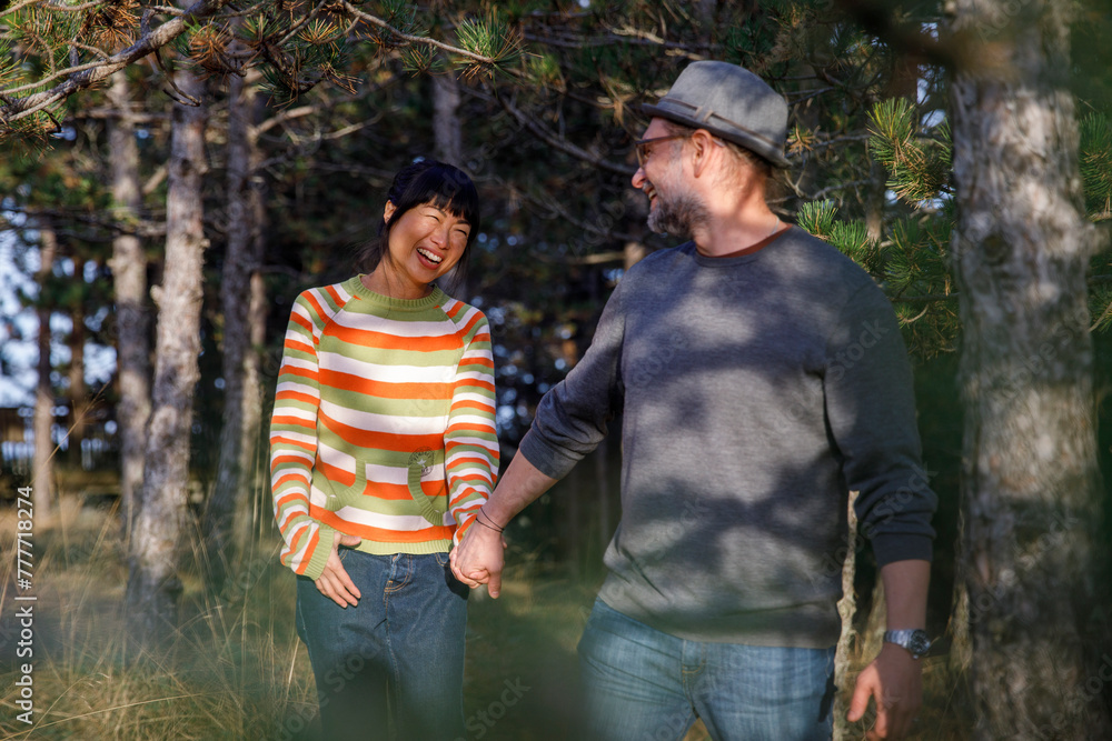 © Jovo Jovanovic/Stocksy - Happy couple walking in forest on vacation © Jovo Jovanovic/Stocksy - Happy couple walking in forest on vacation