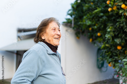 Portrait of a happy senior woman with oranges in the garden. photo