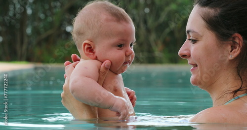 Mother and baby at the swimming pool holding toddler son