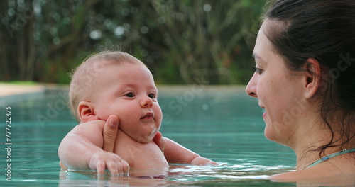 Mother and baby at the swimming pool holding toddler son