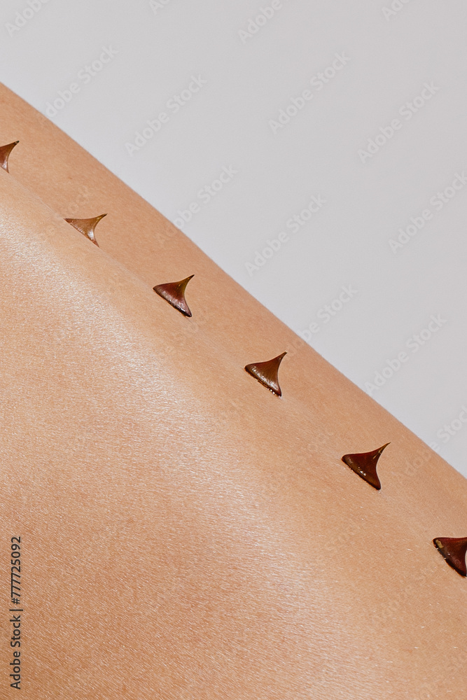 Close up photo of woman's skin texture of back with thorns on spine ...