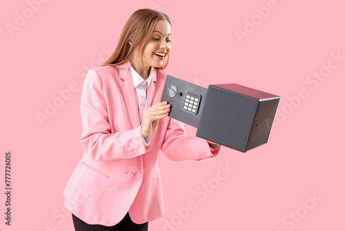 Beautiful young happy woman with safe box on pink background © Pixel-Shot