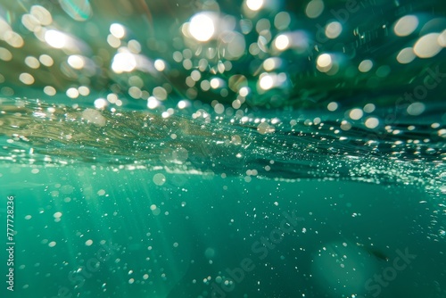 Bubbles and bokeh underwater in a clear green ocean