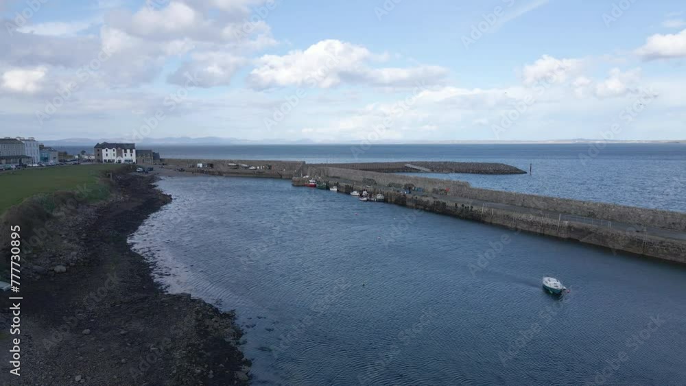 A low drone shot moving towards the pier at Mullaghmore, Co. Sligo, Ireland A low drone shot moving towards the pier at Mullaghmore, Co. Sligo, Ireland