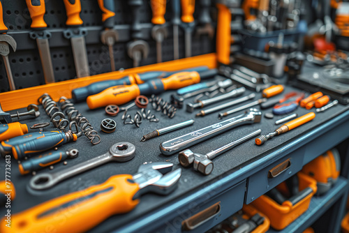 A close-up view of various tools commonly used in auto mechanics neatly organized on a table. The tools include screwdrivers, wrenches, pliers, hammers, and sockets among others