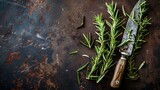 Fresh green rosemary branches and knife on rustic dark brown metal background