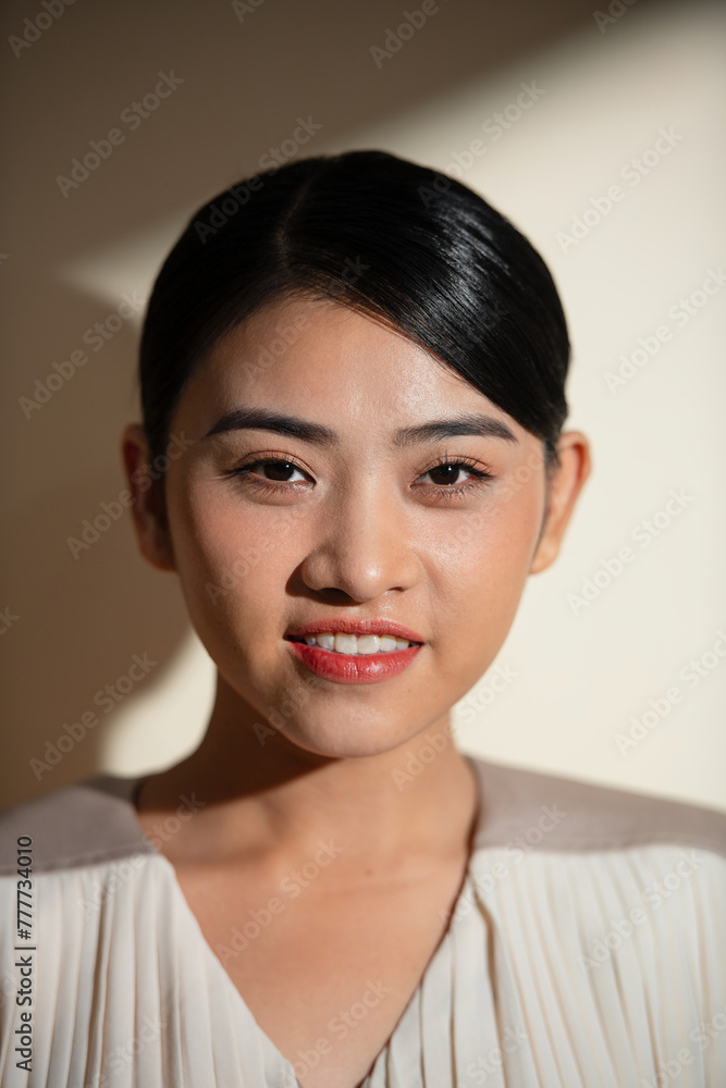Attractive businesswoman standing near wall in office with hard light Attractive businesswoman standing near wall in office with hard light