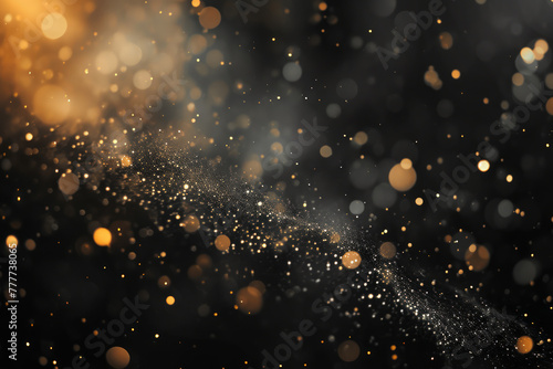 Abstract defocused bokeh yellow lights, golden dust, particles on black background photo