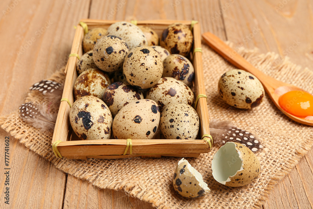Box and spoon with fresh quail eggs on wooden background Box and spoon with fresh quail eggs on wooden background