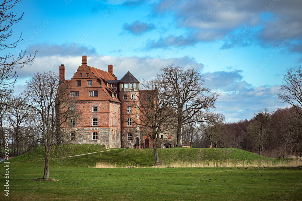 Ulrichshusen Castle is an important Renaissance building in the Mecklenburg Lake District in Germany, the brick building in the landscape park is now used as a hotel, blue sky with clouds, copy space