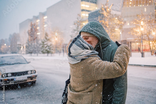 Tender Kiss Amidst a snowfall in the empty city photo