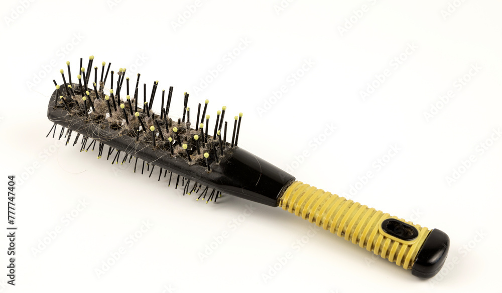 A round hair brush. Dirty hair brush on a white background. The concept of hair loss. A round hair brush. Dirty hair brush on a white background. The concept of hair loss.