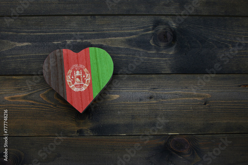 wooden heart with national flag of afghanistan on the wooden background.