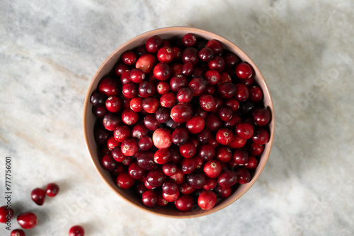 Just harvested cranberries in bowl on marble table photo