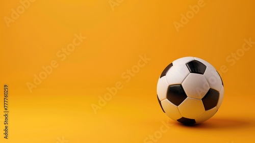 Classic black and white soccer ball sits on solid vibrant orange background with plenty of space around it
